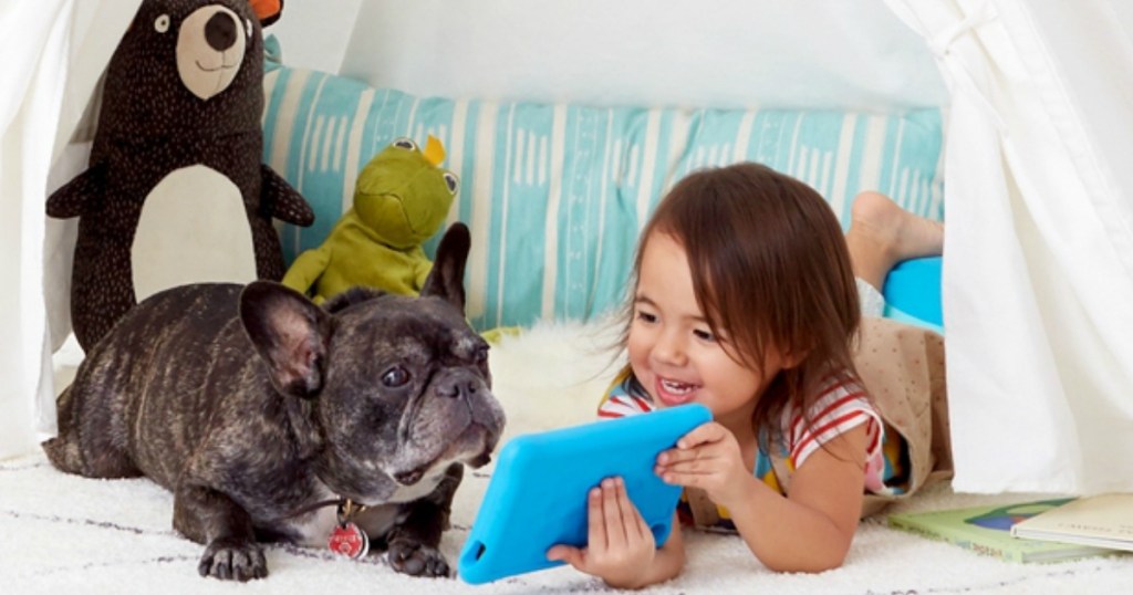 little girl showing her bulldog her blue kindle fire tablet