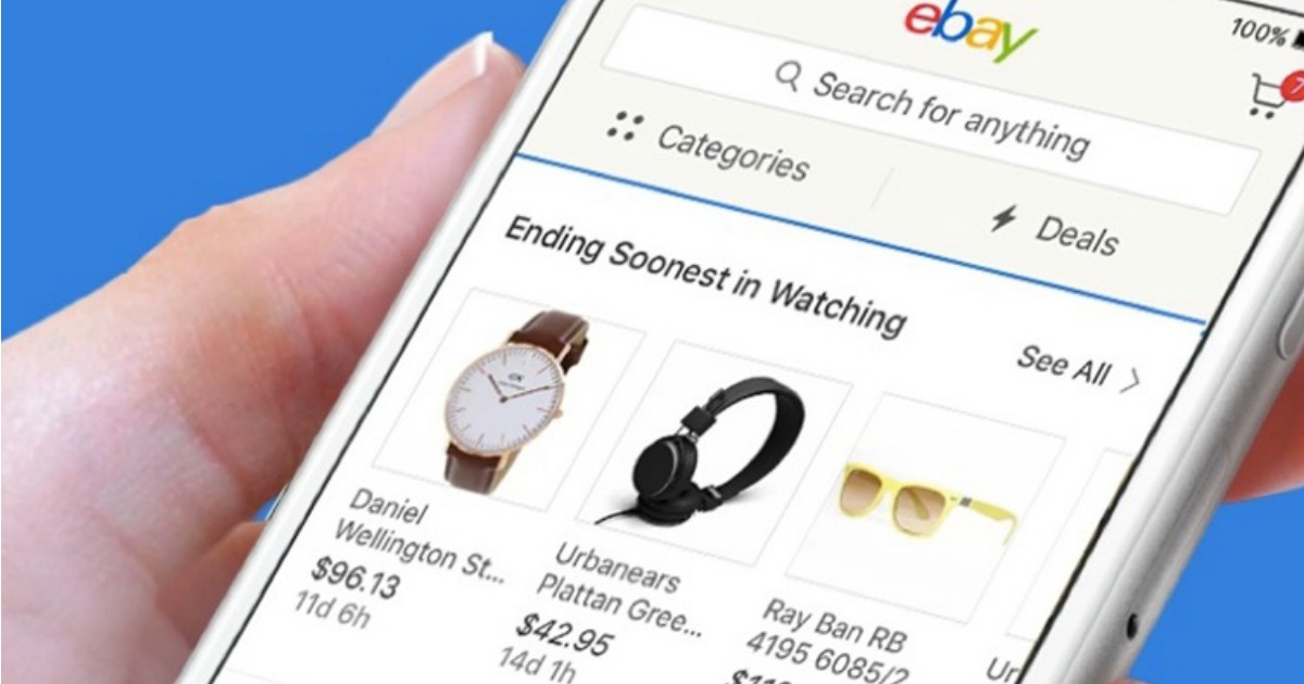 hand holding a smart phone displaying the ebay site on the screen