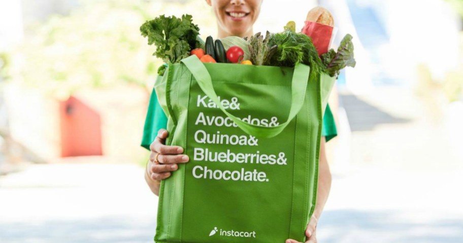 woman holding a reusable instacart shopping bag