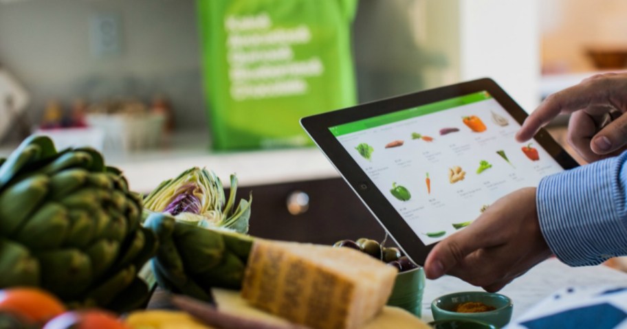 A person loading grocery items onto an Instacart list