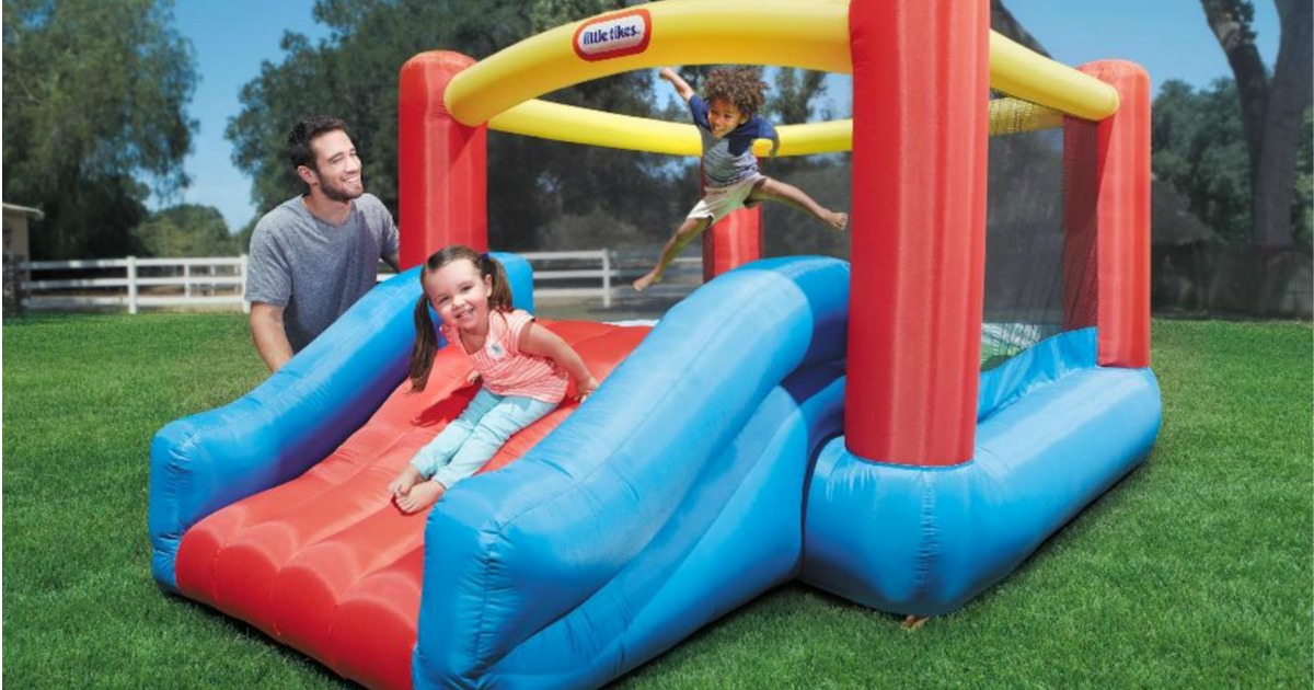 Family outdoors playing on an inflatable bounce house