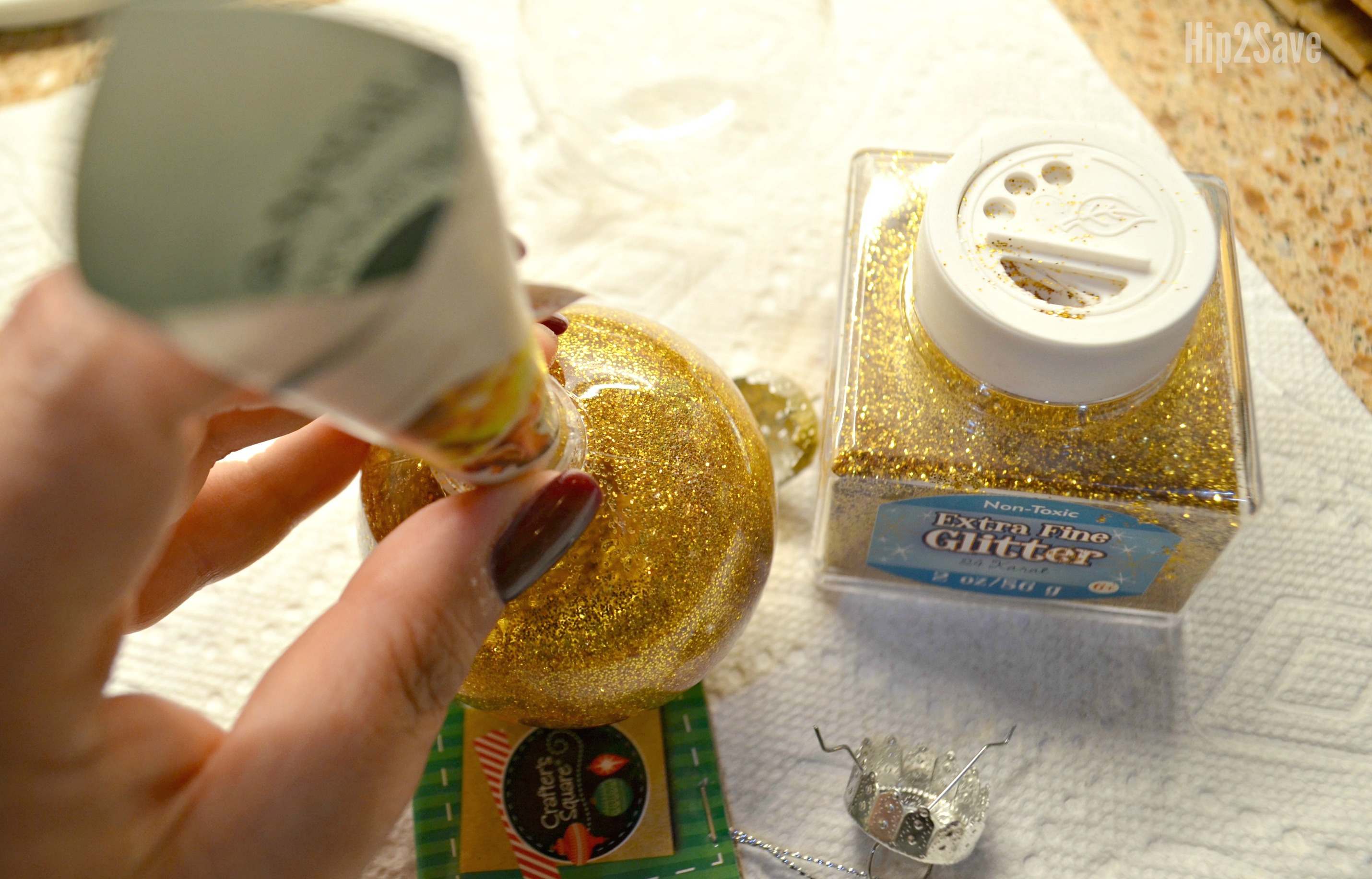 hand filling a clear ornament with glitter as part of our diy ornament ideas with clear balls