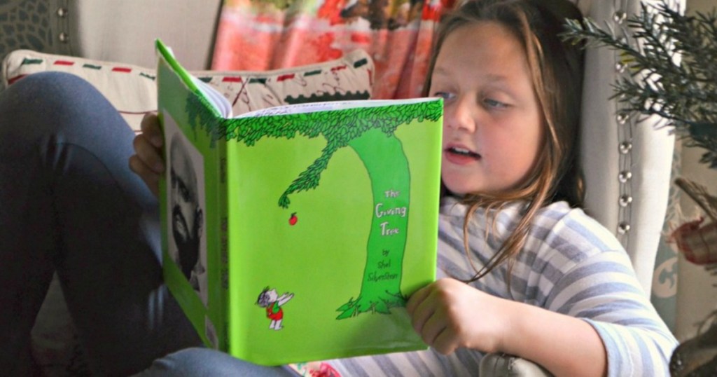 little girl reading the giving tree book