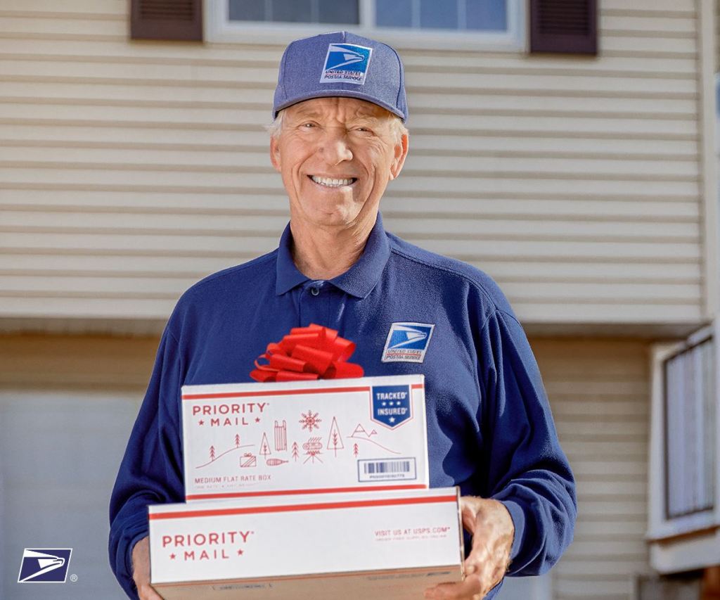 mailman holding priority mail flat rate boxes 