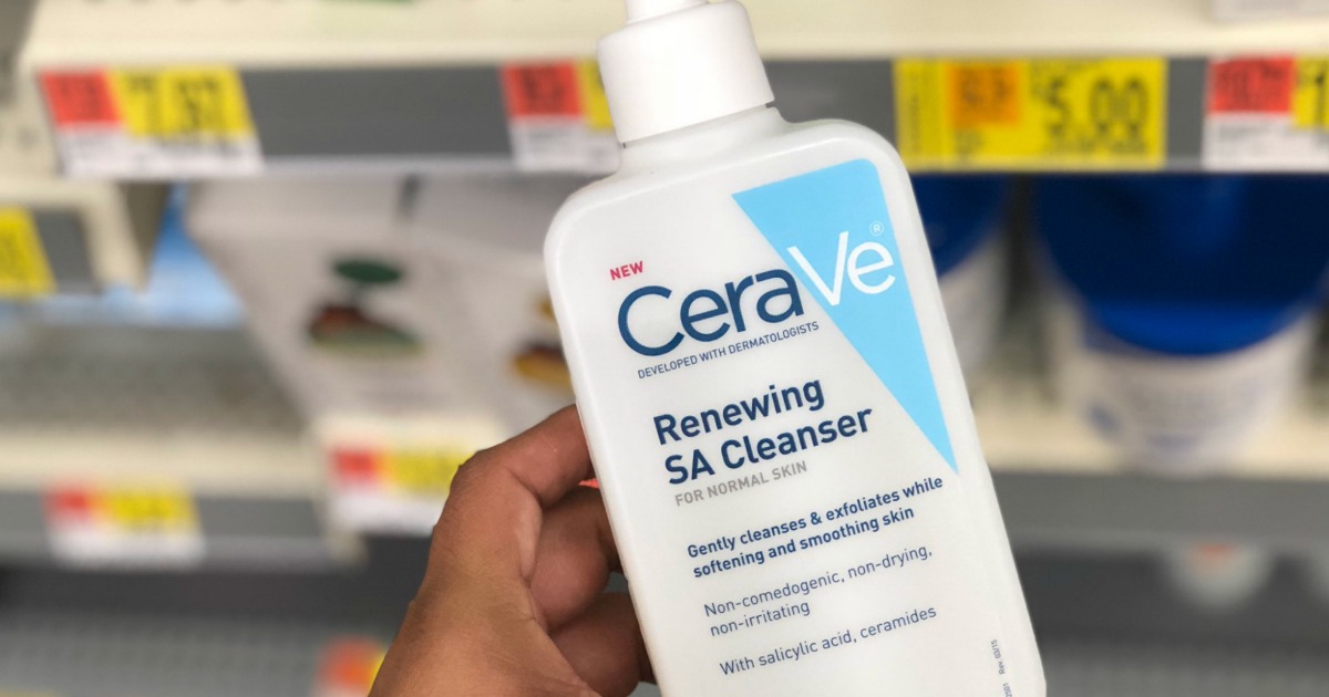 hand holding bottle of CeraVe Renewing SA Cleanser in front of a walmart store shelf