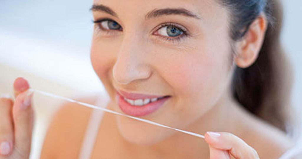 girl holding oral b dental floss in picture