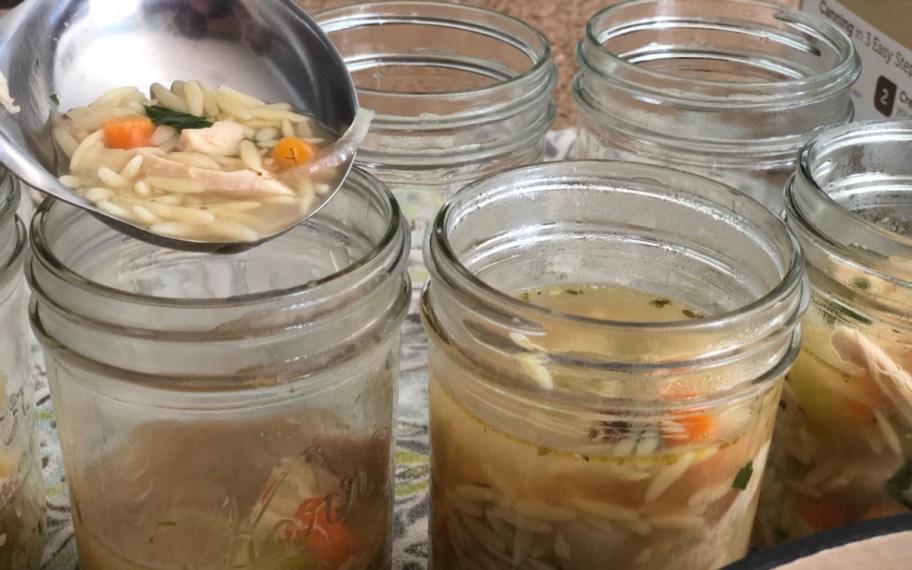 pouring soup into mason jars in order to demonstrate the ease of freezing soup