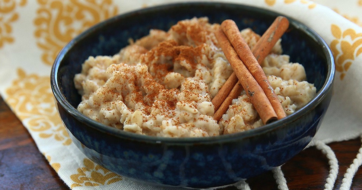 blue bowl of oatmeal garnished with cinnamon sticks