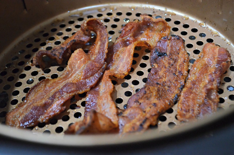 bacon cooking in an air fryer, one of our favorite air fryer hacks
