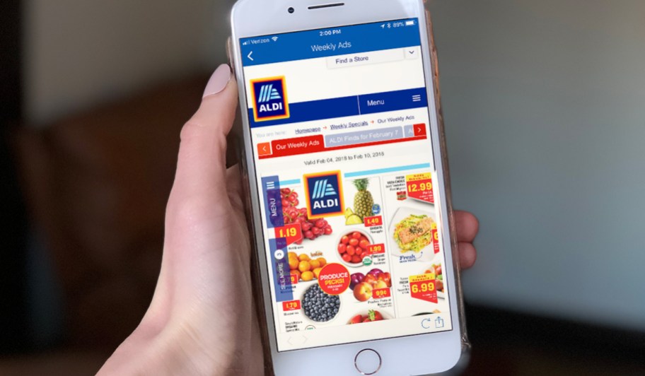 holding phone with ALDI app