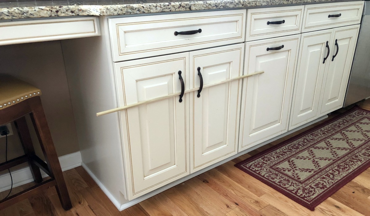use wooden dowels to stop cabinets from opening