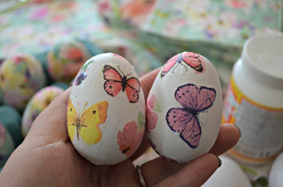 hand holding paper easter eggs or decoupage easter eggs