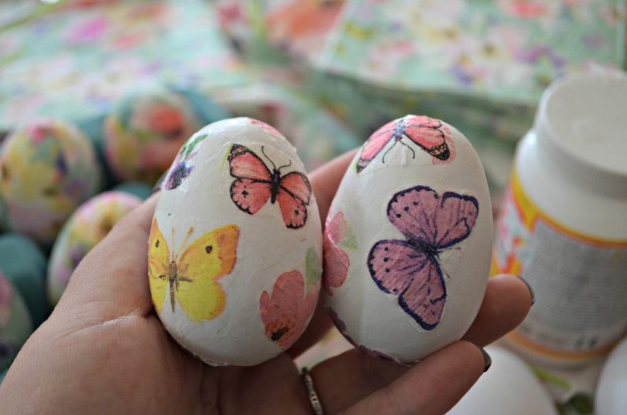 hand holding paper easter eggs or decoupage easter eggs