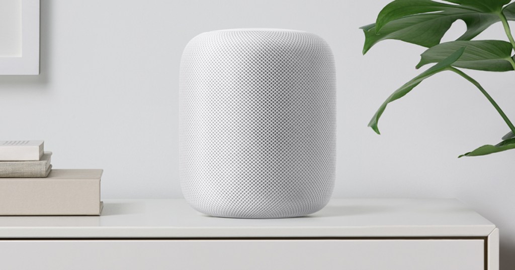 small, white Apple speaker on end table near plant