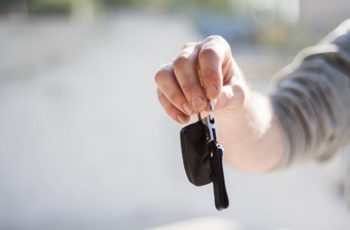 person holding up car keys