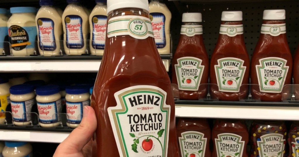hand holding bottle of red ketchup 