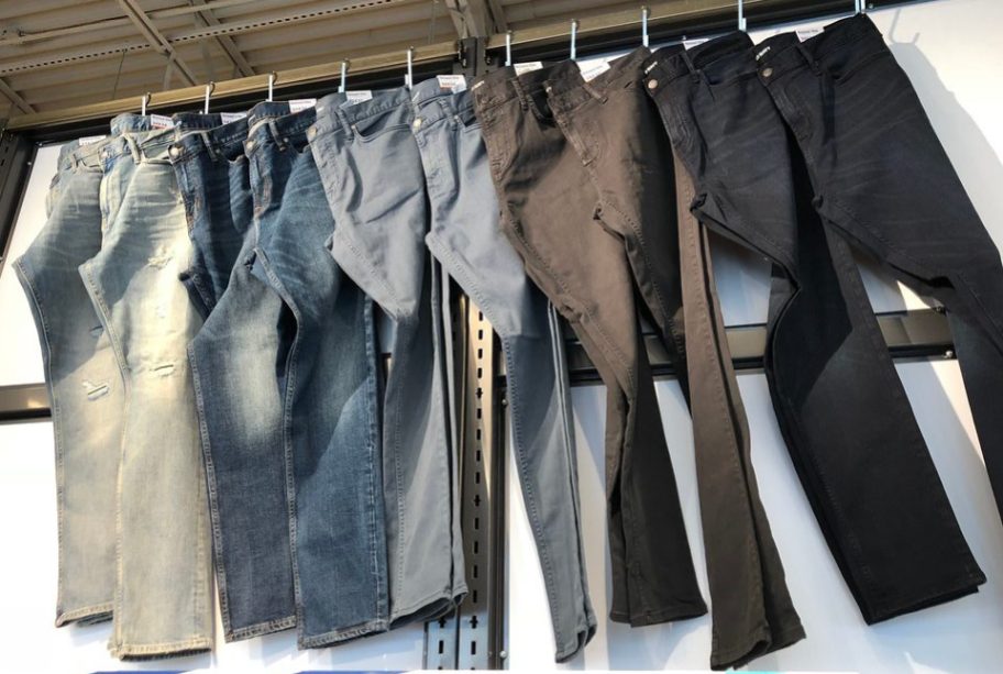 blue, gray and black jeans hanging in store