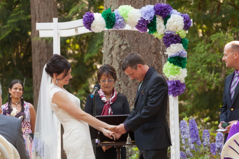 bride and groom holding hands at wedding ceremony - dollar tree wedding