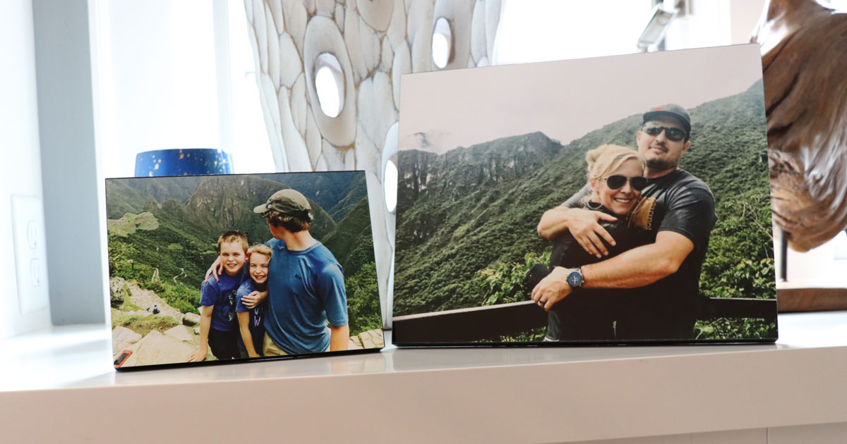 two wooden photo prints on white counter of kids and couple in the mountains