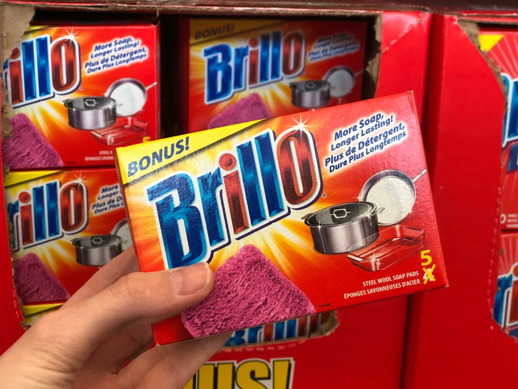 hand holding a pack of red brillo pads
