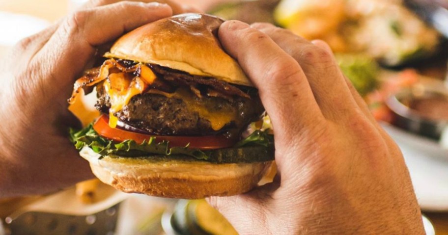 hand holding up Chili's Classic Bacon burger