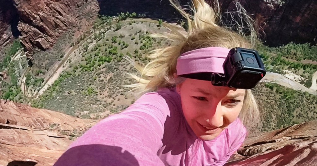 woman on cliff wearing a GoPro camera