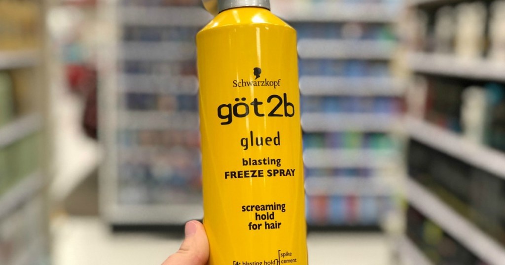 hand holding yellow hair spray bottle