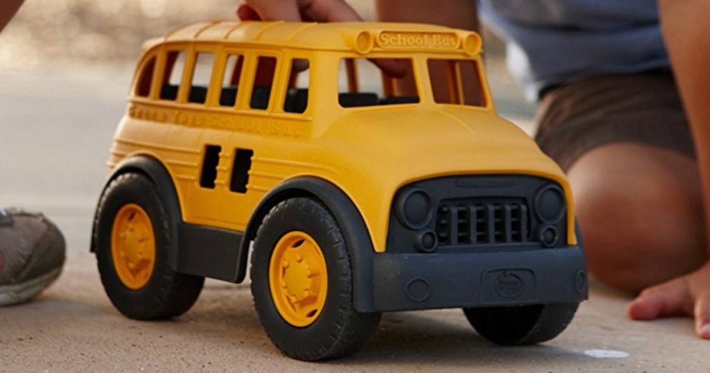 child playing with yellow school bus toy