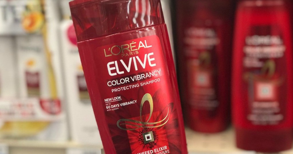 Red bottle of L'Oreal Elvive held up to display in front of other shampoos at Walgreens