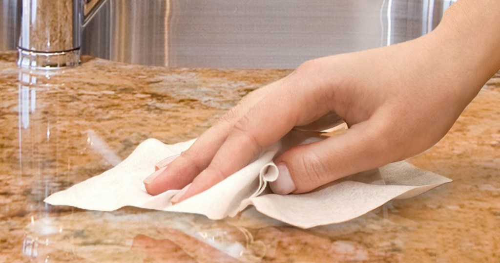 woman hand cleaning counter top with wipe