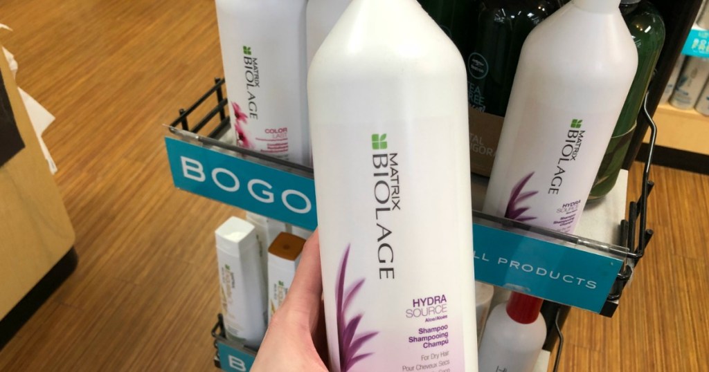 Matrix Biolage liter shampoo being held in front of display