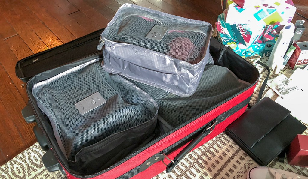use packing cubes to organize outfits in your suitcase hip2save