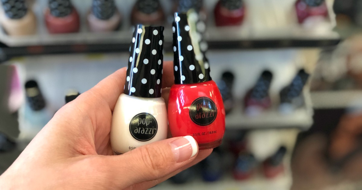 two bottles of pop-arazzi nail polish in white and red being held in store