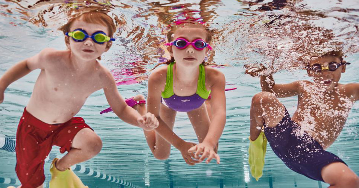 Kids swimming in a pool wearing speedo swimwear