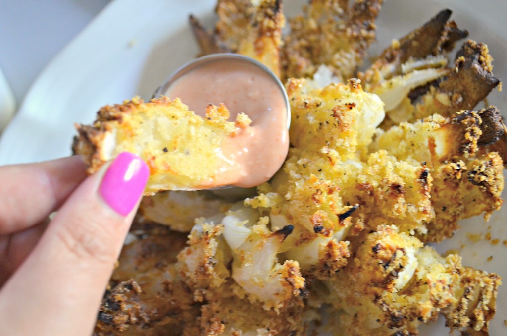dunking air fryer bloomin' onion in sauce 