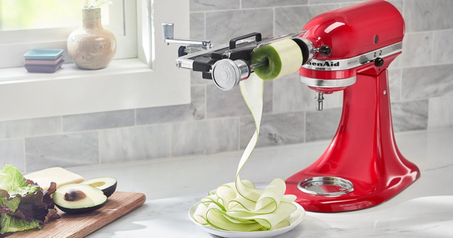 red kitchenaid with sheet cutter attachment cutting zucchini into bowl on counter