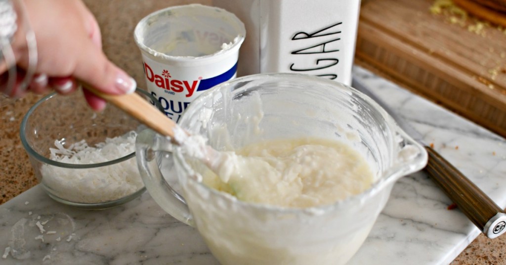 mixing sour cream with sugar and coconut