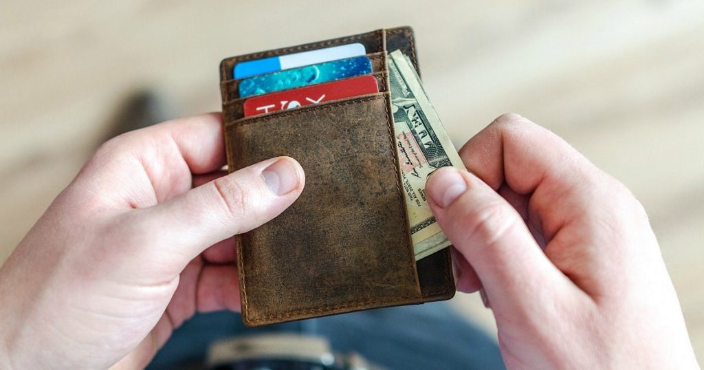putting money into wallet
