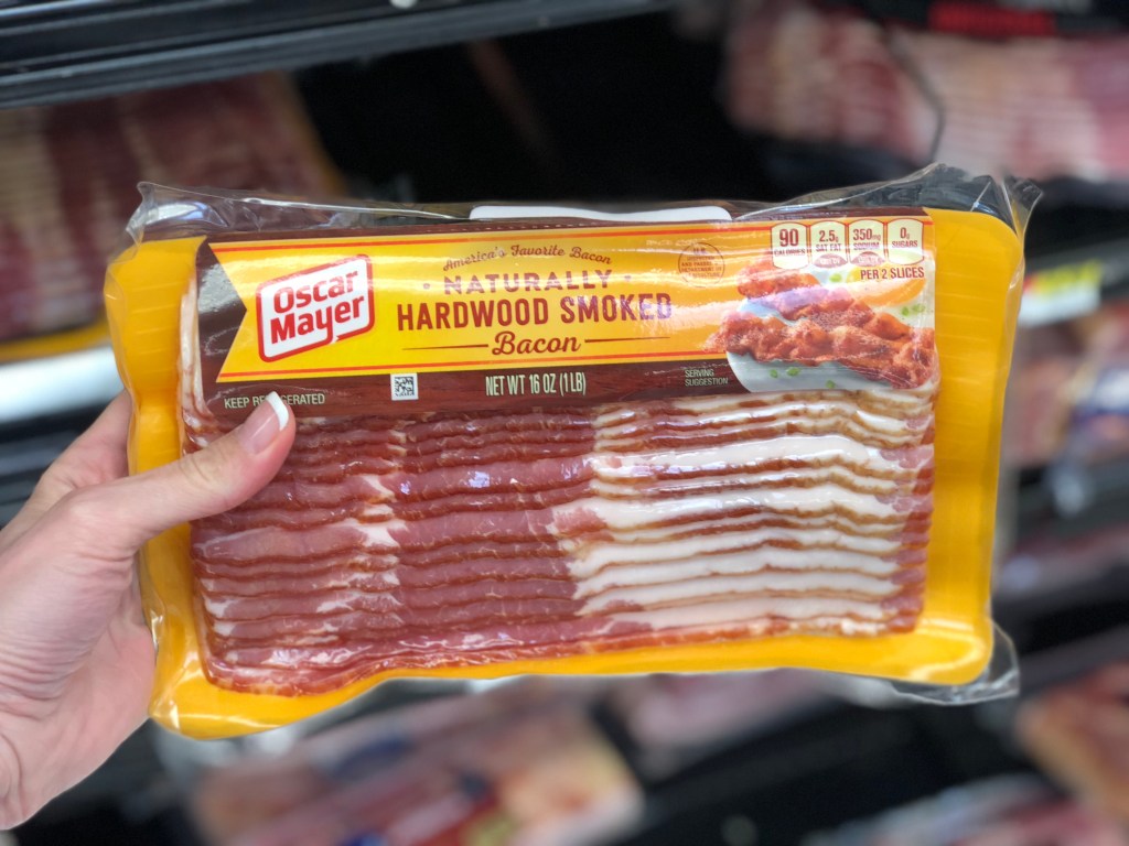 holding a package of bacon