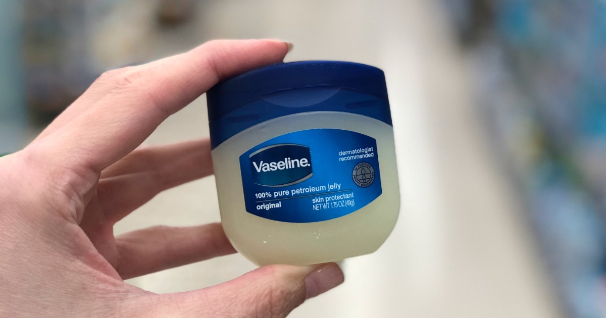 hand holding small jar of Vaseline in store aisle.