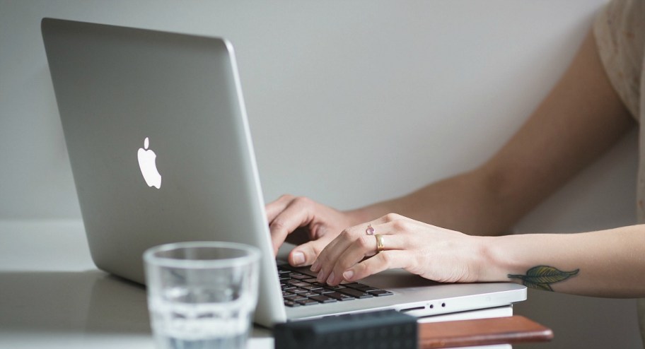 person typing on macbook laptop