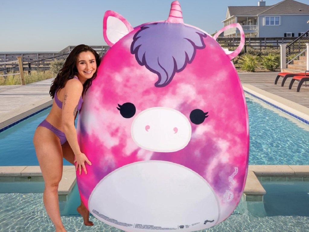 Girl Standing next to a Huge Squishmallows Unicorn Pool Float