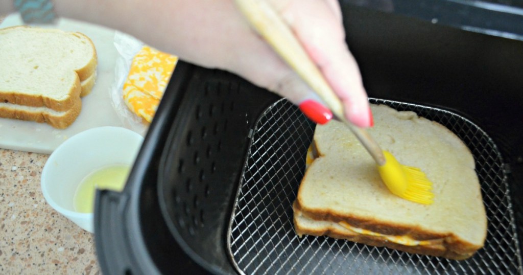 spreading butter on a slice of bread in air fryer