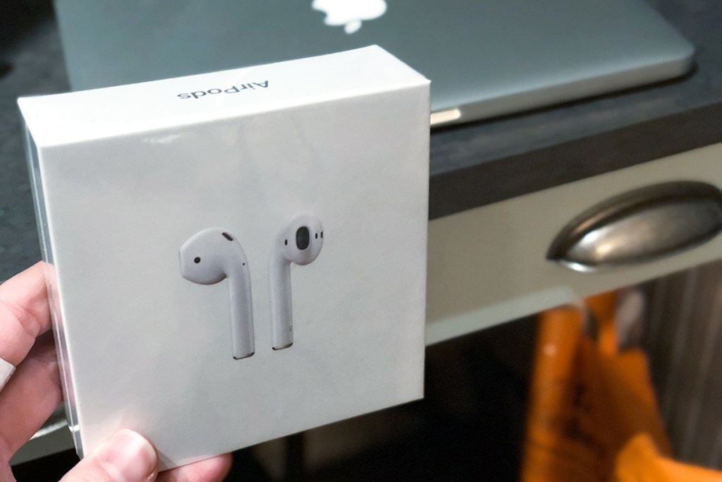 hand holding box with apple airpods