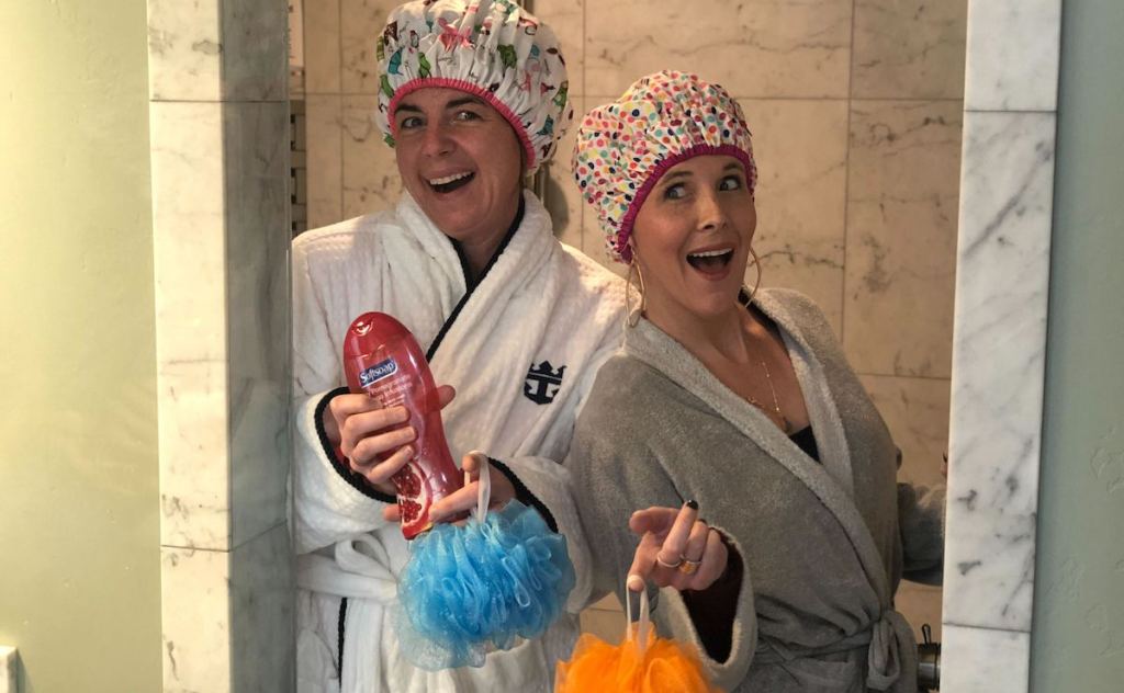 two women standing in shower with shower caps and lufas