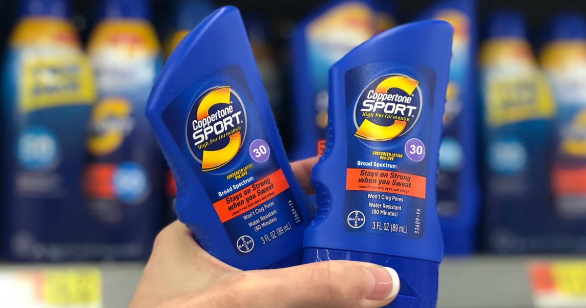 hand holding up two bottles of coppertone sunscreen