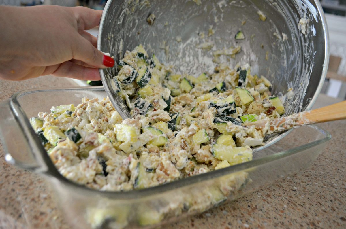 easy chicken zucchini casserole recipe -- ingredients being spooned into the baking pan