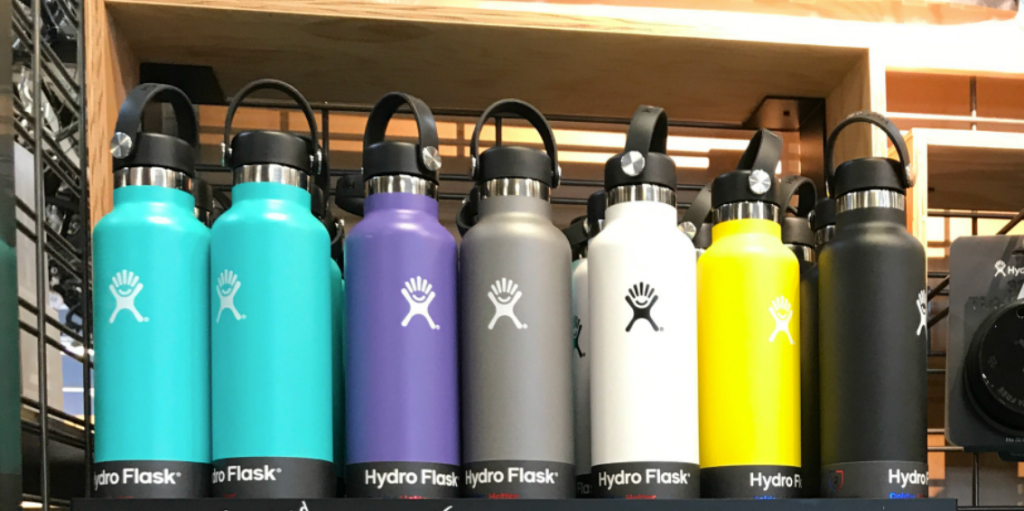 collection of Hydro Flask stainless steel bottles in various colors lined up on a shelf
