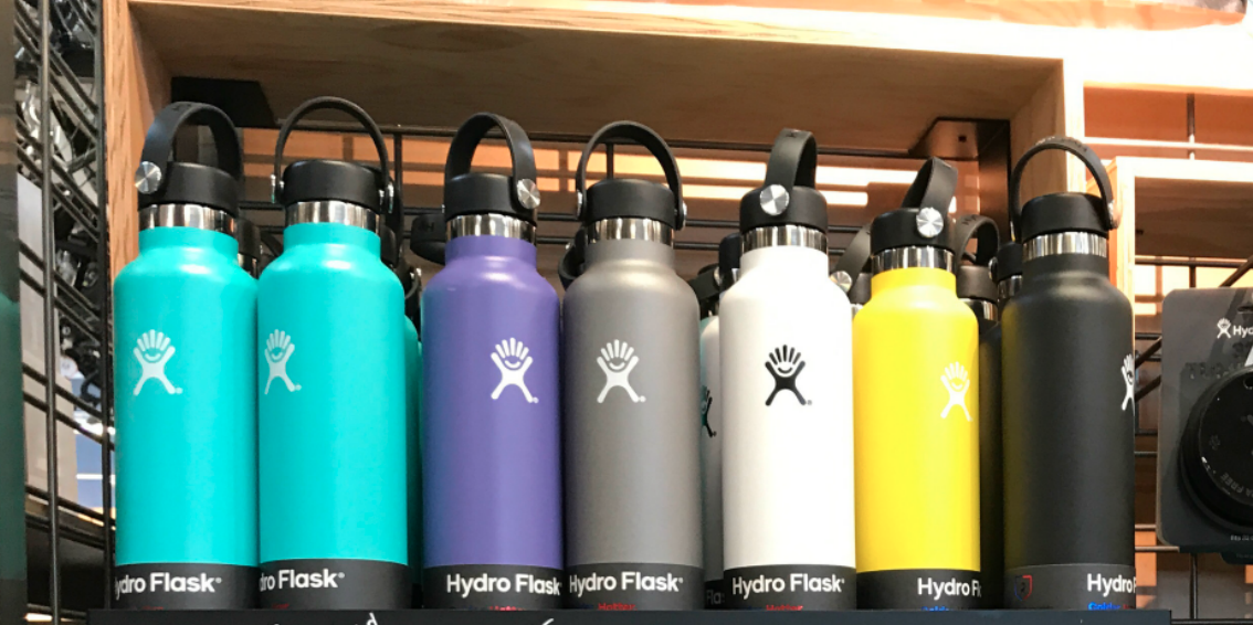 collection of Hydro Flask stainless steel bottles in various colors lined up on a shelf