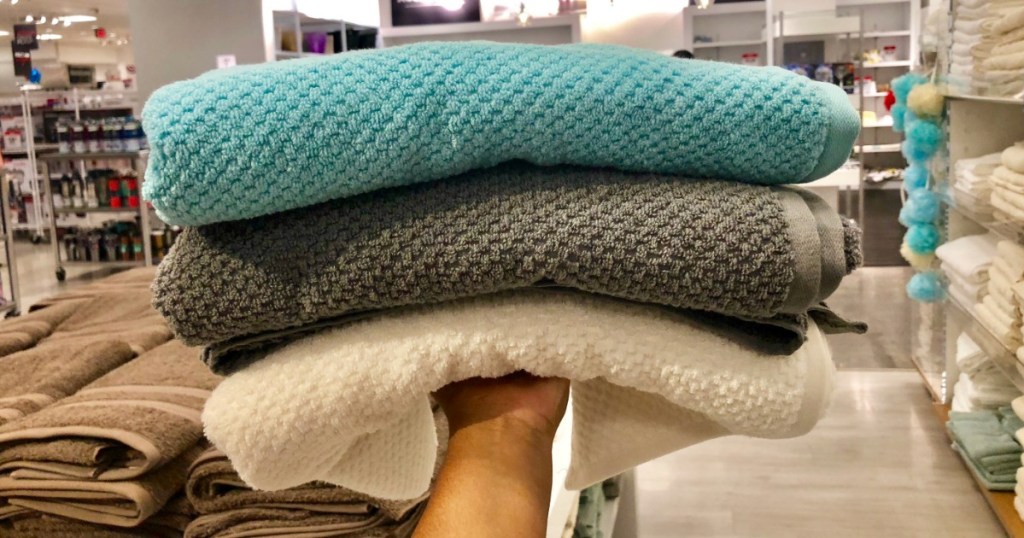 hand holding bath towels in store